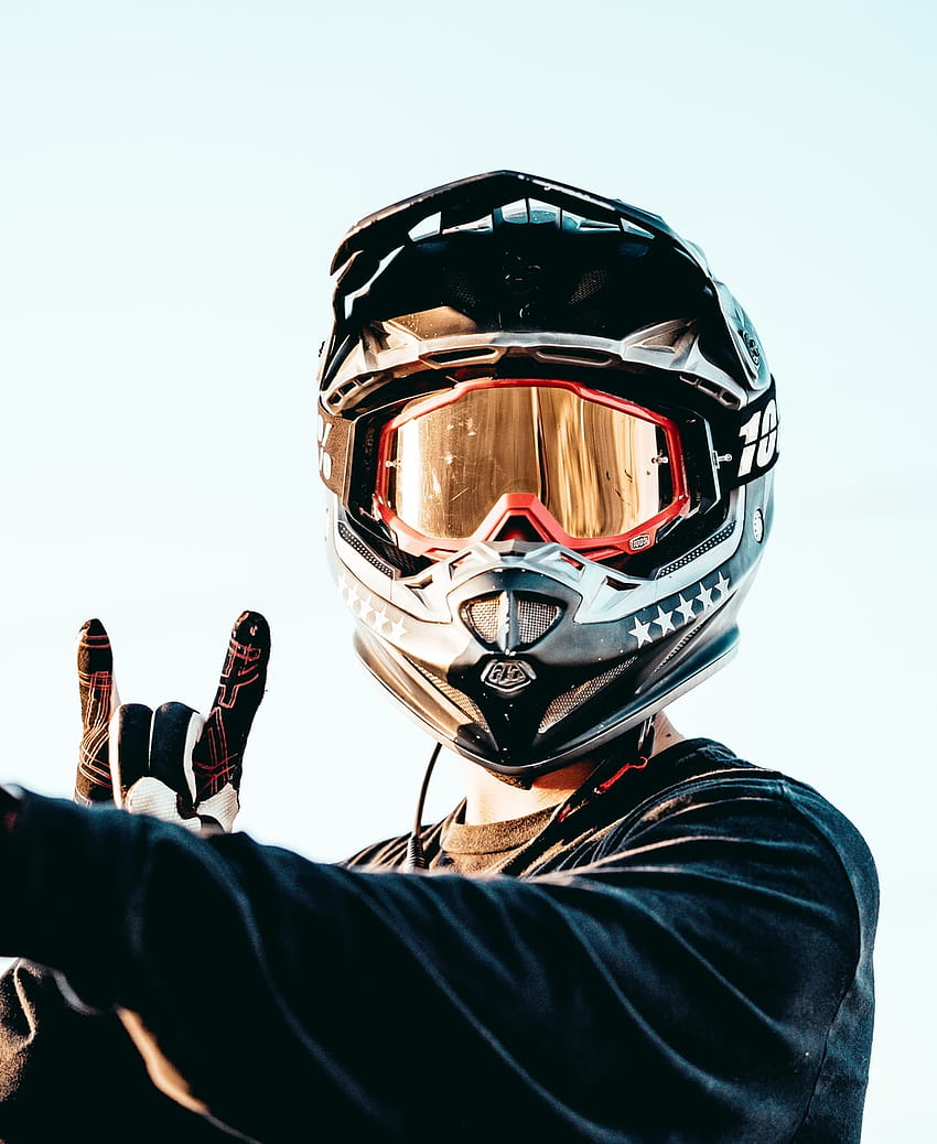persona con casco negro y naranja y chaqueta negra â en Unsplash, casco de motocross fondo de pantalla del teléfono